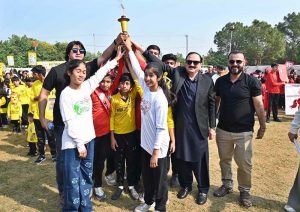 Secretary Workers Welfare Fund Zulfiqar Ahmad joins students holding torches to kick off the opening ceremony of Kaiynaat School System’s Annual Sports Gala 2025 at Sector I-10.