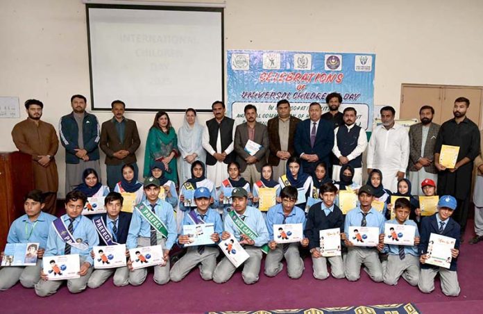 A view of group photo of Deputy Director National Commission for Human Development Umar Daraz Jhawari and others along with students during the ceremony titled 'World Children Day 2025' jointly organised by Child Protection and Welfare Bureau and National Commission for Human Development at DPS School
