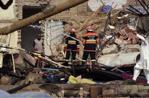 Rescue 1122 personnel remove debris from nearby houses that collapsed after a gas-boiler explosion in a chemical factory near Chak No. 203-RB Malik Pur, which caused multiple deaths and left several others injured