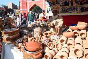 An artist making traditional music instrument Rubab at his stall during the ten-day annual folk festival “Lok Mela 2025” at Lok Virsa.
