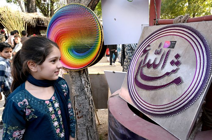 A girl visits a stall at the Ten-Day annual folk festival “Lok Mela 2025” at Lok Virsa