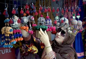 A cook grills fresh BBQ, drawing visitors with its tempting aroma during the ten-day annual folk festival “Lok Mela 2025” at Lok Virsa.