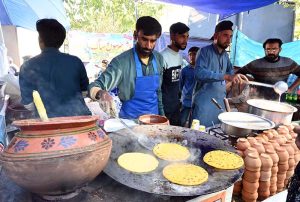 An artist making traditional music instrument Rubab at his stall during the ten-day annual folk festival “Lok Mela 2025” at Lok Virsa.
