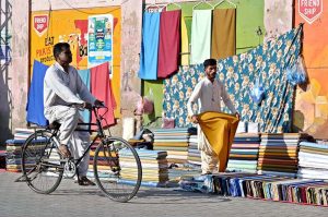 People browse and purchase warm clothing at a roadside stall on Old Bus Stand Road amid the onset of winter