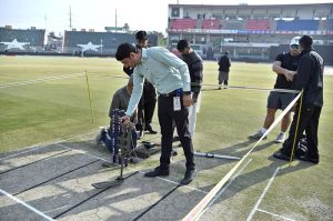 Security officials check the cricket ground and pitch with a metal detector before the start of the Pakistan vs Zimbabwe T20 Tri-Series match at Rawalpindi Cricket Stadium.