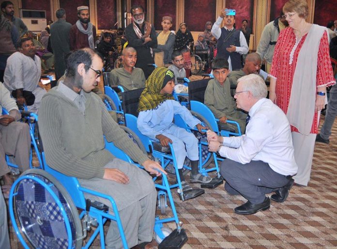 Humanitarian specialists Mr. and Mrs. Michal Pope interact with a special child during a customized wheelchair distribution ceremony jointly organized by the Church of Jesus Christ of Latter-day Saints and the Society for Special Persons