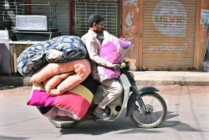 A motorcyclist on the way loaded with quilts at Fort Road.
