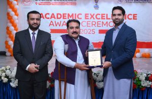 Executive Director strategy and Coordination City University Science & Information Technology Muhammad Ayoub Sethi presenting a shield to Secretary Mardan Board Prof. Hazrat Ali during Academic Excellence Award Ceremony 2025 of PMDC