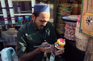 An artist making traditional music instrument Rubab at his stall during the ten-day annual folk festival “Lok Mela 2025” at Lok Virsa.