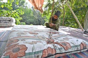 A worker is busy stitching a quilt for a customer at his workplace in Sector G-7 of the Federal Capital