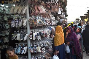 Women select and purchase clothes at the G-9 weekly bazaar in the Federal Capital