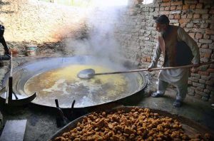 An elderly man prepares the traditional sweetener jaggery 'Gur' from sugarcane juice at Tang Koruna in the Charsadda area.