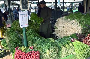 A vendor displays fresh vegetables at his stall to attract customers at the G-9 weekly bazaar in the Federal Capital