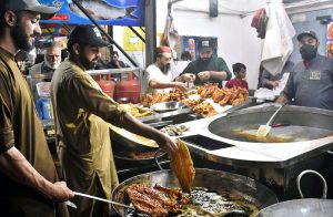 A shopkeeper is preparing, steaming and frying fish for eager customers as the demand for winter dishes increases with the drop in temperatures.