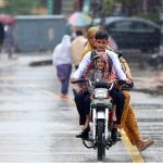 A family getting soak during the first rain of the season in the federal capital as temperatures started to drop