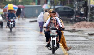 A family getting soak during the first rain of the season in the federal capital as temperatures started to drop