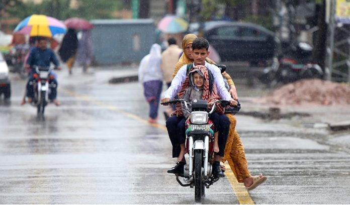 A family getting soak during the first rain of the season in the federal capital as temperatures started to drop