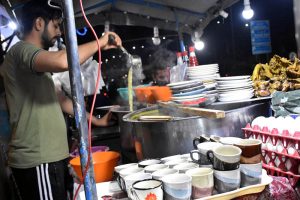 A vendor serves steaming hot chicken corn soup to customers as the winter chill boosts demand for warming street foods across the city