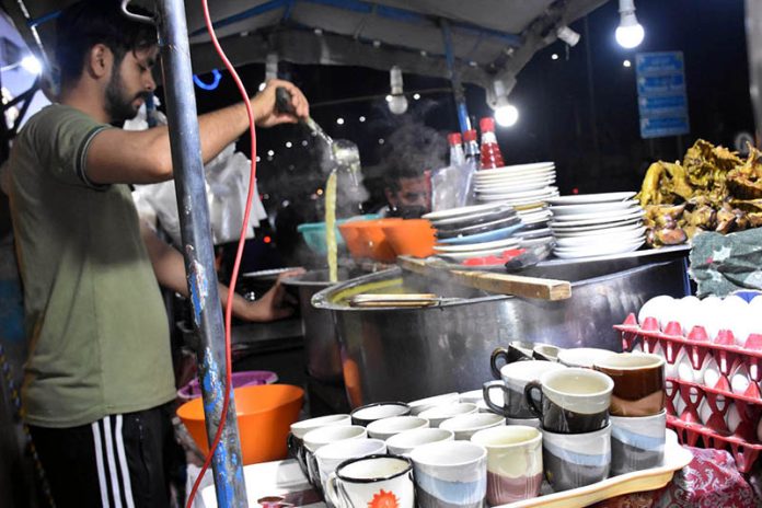 A vendor serves steaming hot chicken corn soup to customers as the winter chill boosts demand for warming street foods across the city