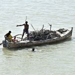 A view of fisherman busy in collecting and loaded woods on the boat at Indus River