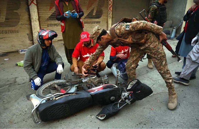 Rescue and security personnel collect evidence at the scene of a suicide attack on the Federal Constabulary headquarters, where three FC soldiers were killed and 11 civilians injured