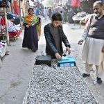 A young vendor sells sunflower seeds at the I-9/4 weekly bazaar in the Federal Capital.