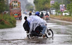 A family getting soak during the first rain of the season in the federal capital as temperatures started to drop