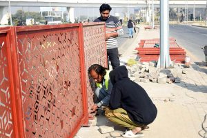 Workers busy installing fencing along the roadside as part of the provincial capital’s beautification efforts.