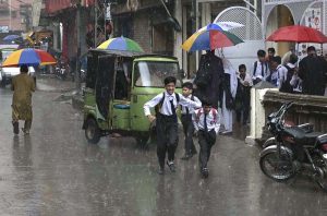 A family getting soak during the first rain of the season in the federal capital as temperatures started to drop