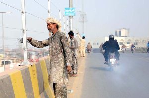 Labourers painting the safety fence at Kalma Chowk to improve roadside safety.