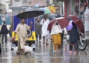 A schoolboy gets drenched while playing and splashing in the season’s first winter rain, celebrating the arrival of the chilly weather
