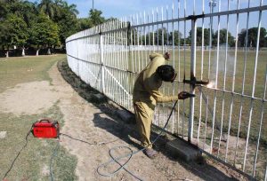 A welder busy in welding a damaged grill installed on the cricket ground at the Bahawalpur Stadium.
