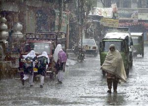 A schoolboy gets drenched while playing and splashing in the season’s first winter rain, celebrating the arrival of the chilly weather