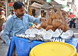 A street vendor sells coconuts from his handcart at Urdu Bazaar, striving to earn a livelihood for his family.