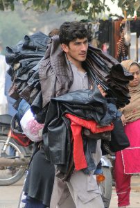 A vendor cutting sweet potatoes for the customers at his roadside setup