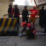Rescue and security personnel collect evidence at the scene of a suicide attack on the Federal Constabulary headquarters, where three FC soldiers were killed and 11 civilians injured