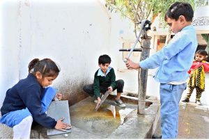 Students wash and prepare their traditional wooden slates, known as “Takhti,” at Al-Farooq Science School System at Boori.