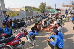 A large number of deserving people sitting for getting free food at Noori Gate.