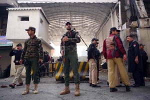 Rescue and security personnel collect evidence at the scene of a suicide attack on the Federal Constabulary headquarters, where three FC soldiers were killed and 11 civilians injured