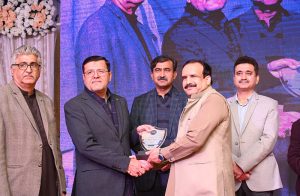 Vice Chancellor University of Jhang, Prof. Dr. Faheem Aftab, is selecting a raffle for free Umrah Tickets for employees at an Annual Dinner in honor of employees of scales 1 to 16 at University of Sargodha.