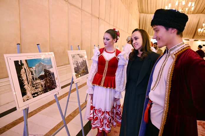 Participants take keen interest in photographs by Russian artists during a ceremony marking the People’s Unity Day of the Russian Federation at a local hotel