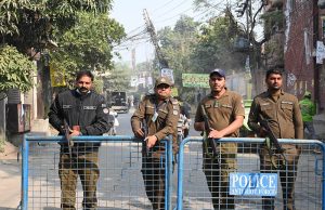 Police personnel stand alert during the by-election in National Assembly constituency NA-129 at Sodiwal