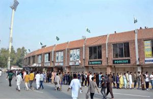 Cricket lovers stand in queue at the entry gate of Iqbal Stadium to attend the first ODI match between Pakistan and South Africa