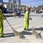 Workers of Rawalpindi Waste Management Company (RWMC) busy cleaning road at Fawara Chowk, Raja Bazaar
