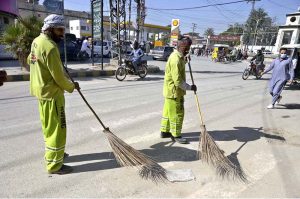 Workers of Rawalpindi Waste Management Company (RWMC) busy cleaning road at Fawara Chowk, Raja Bazaar