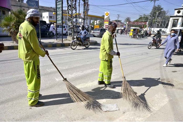 Workers of Rawalpindi Waste Management Company (RWMC) busy cleaning road at Fawara Chowk, Raja Bazaar
