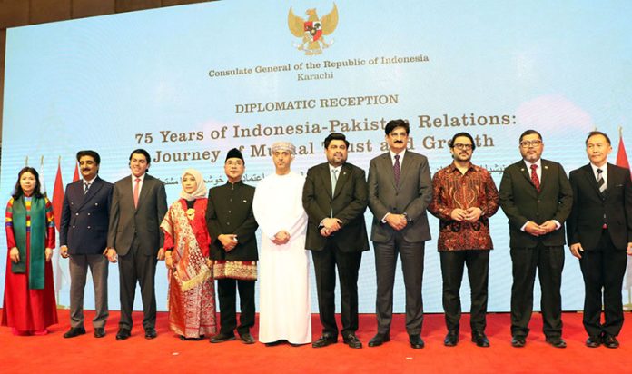 A group photo of Governor Sindh Kamran Khan Tessori, Chief Minister Syed Murad Ali Shah, and host Consul General of Indonesia Drs. Mudzakir M.A pose with diplomats during late-night celebrations of the 80th Anniversary of the Independence Day of the Republic of Indonesia at a local hotel