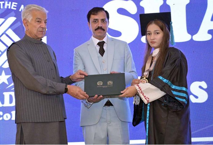 Defence Minister Khawaja Muhammad Asif distributes certificates and shields to successful students during the 14th convocation of Shadab Girls College