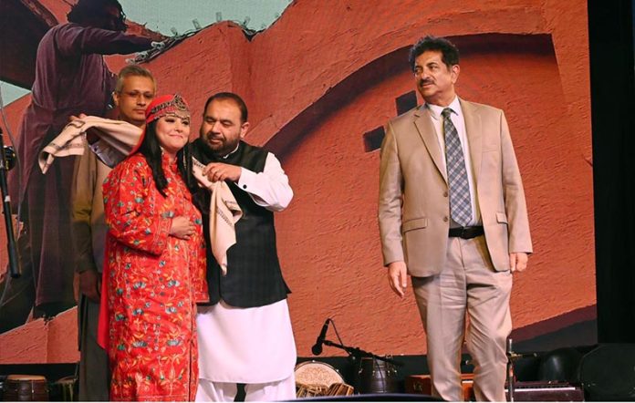 Federal Minister for National Heritage and Culture, Aurangzeb Khan Khichi, presenting a traditional shawl to a folk artist as a mark of respect during the inaugural ceremony of the ten-day annual folk festival “Lok Mela 2025” at Lok Virsa