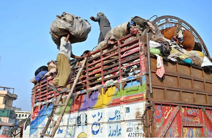 Labourers are busy loading the scrap onto truck